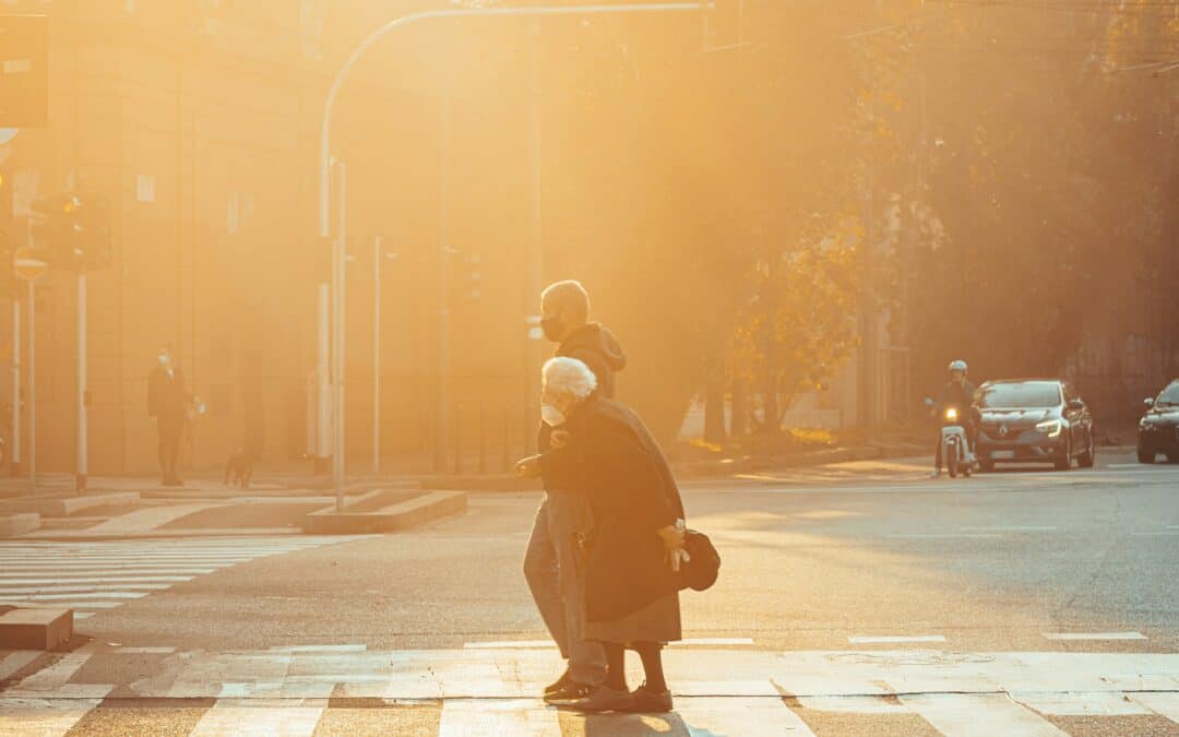 Kuvassa ihmiset kävelemässä kaupunkipäivässä auringonlaskussa, kirkko taustalla, korostaa yhteisöä ja kirkon roolia.